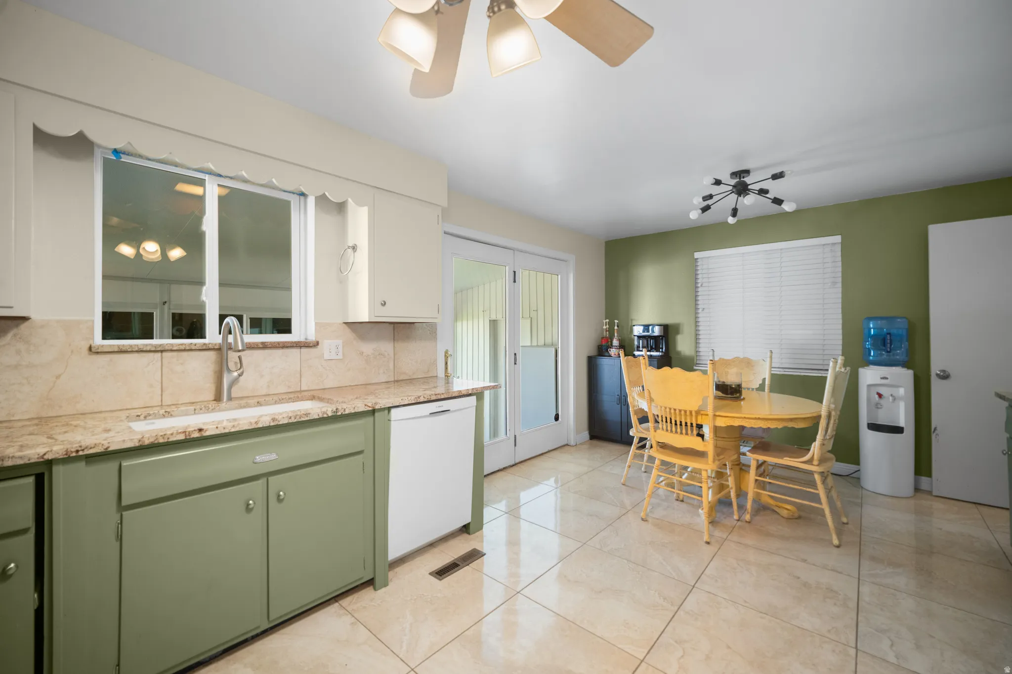 Open-concept kitchen featuring two-tone cabinetry, a porcelain sink, and granite countertops