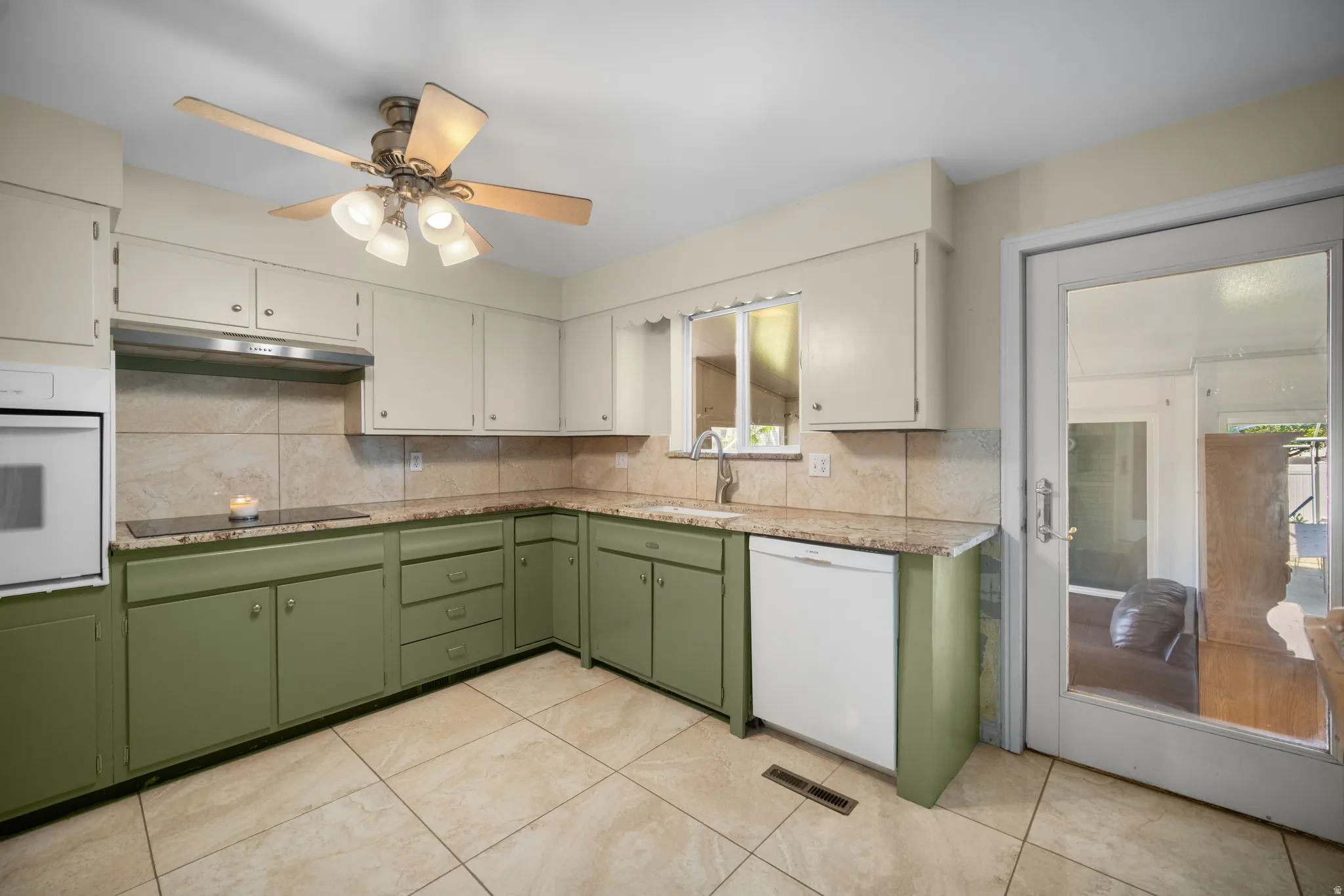 Kitchen featuring tile flooring, light-toned countertops, a built-in oven, and a ceiling fan with integrated lighting