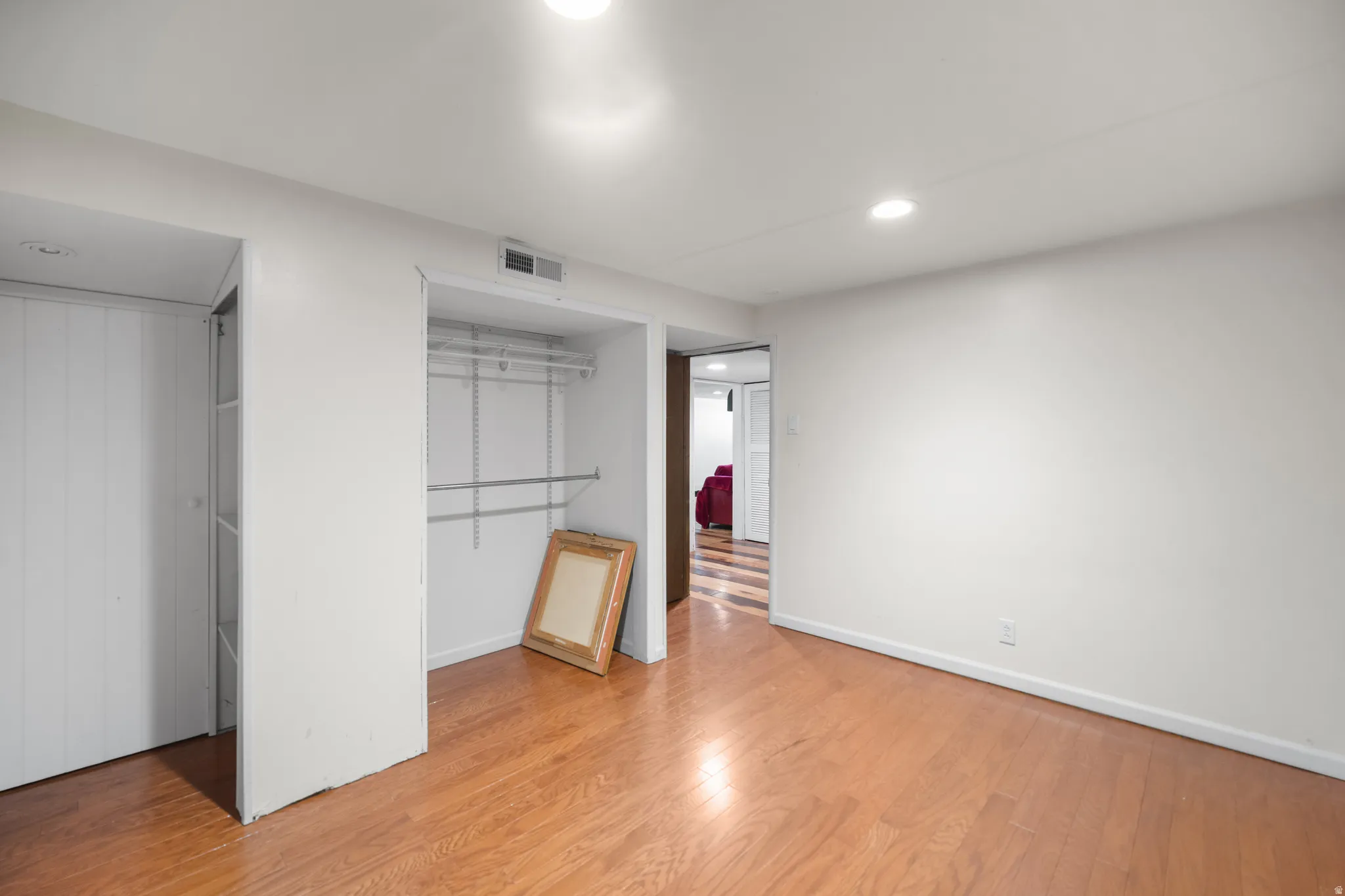 Hardwood flooring throughout this room featuring recessed lighting