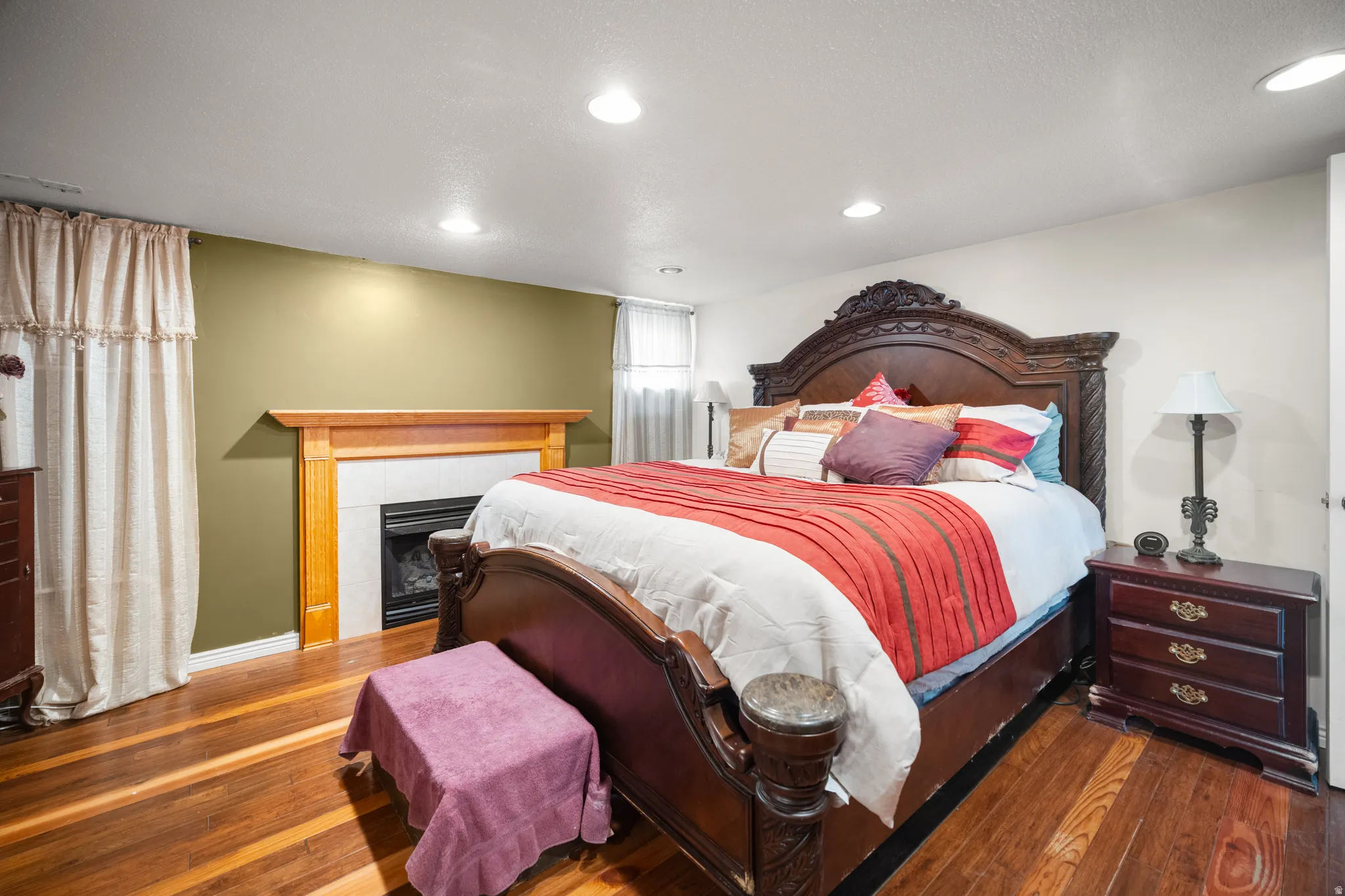 Bedroom with wood-finish flooring, recessed lighting, and a white trim baseboard