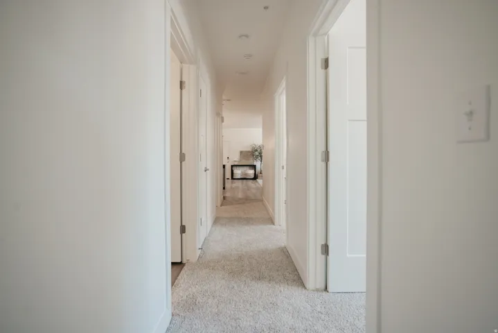 Hallway featuring soft gray carpeting and recessed lighting