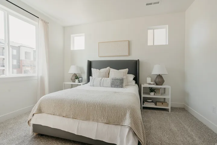 Carpeted room featuring a large window with white trim, two smaller transom windows, and white walls