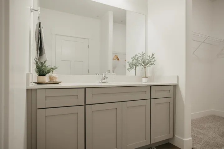 Bathroom vanity featuring a light gray shaker cabinet, white countertop, and integrated sink