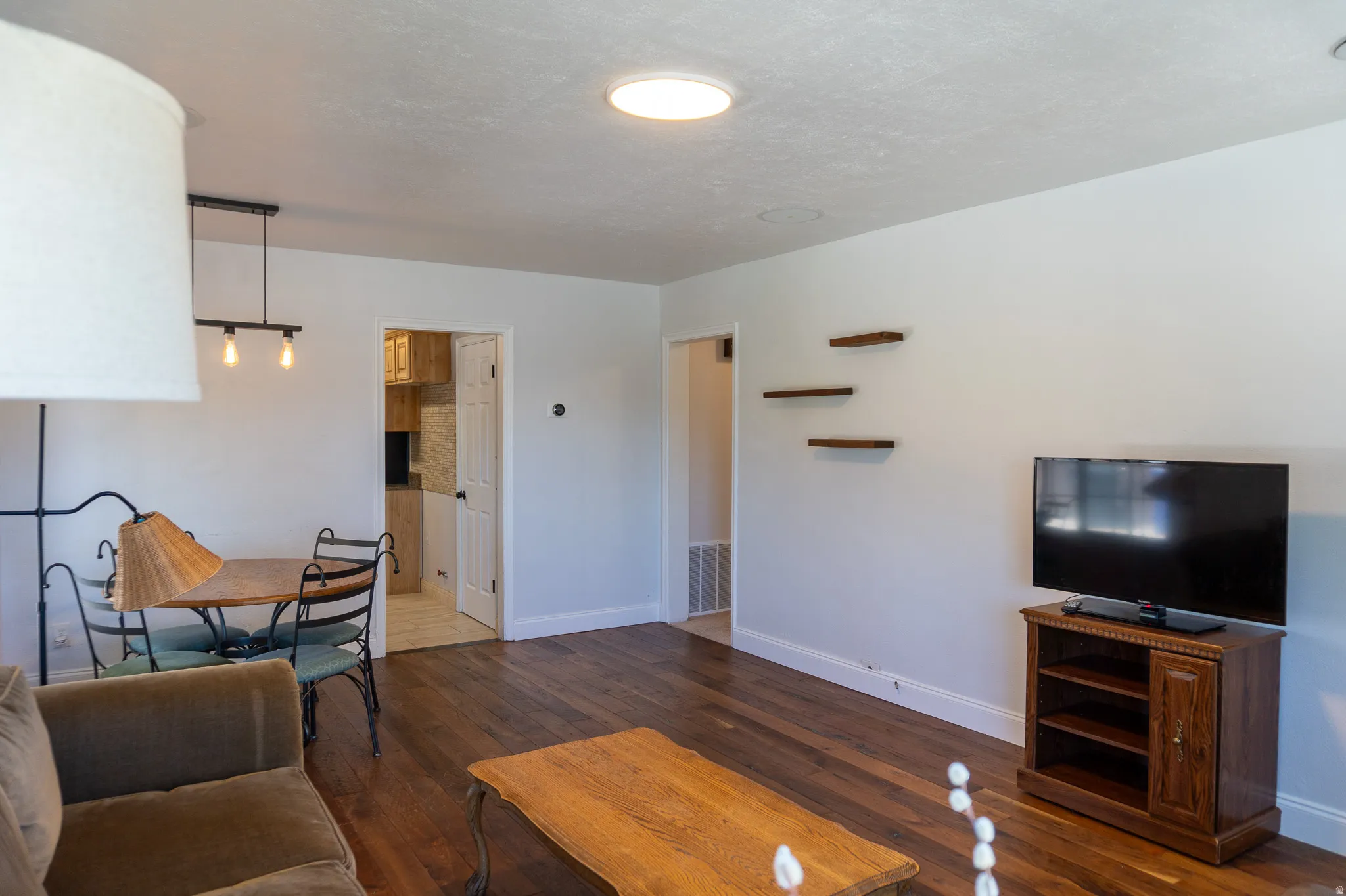 Living area featuring wood-finish flooring, white walls, and a recessed ceiling light