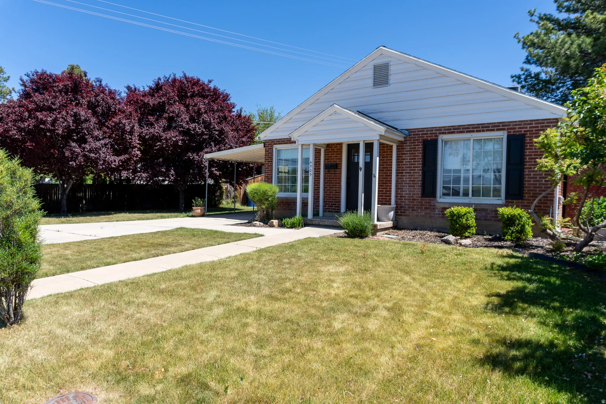 Brick exterior with white siding accents and dark shutters