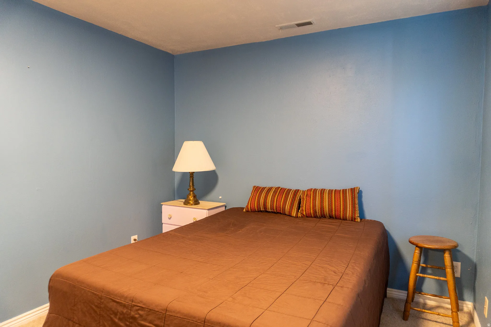 Room featuring light blue painted walls, white baseboards, and carpeted flooring