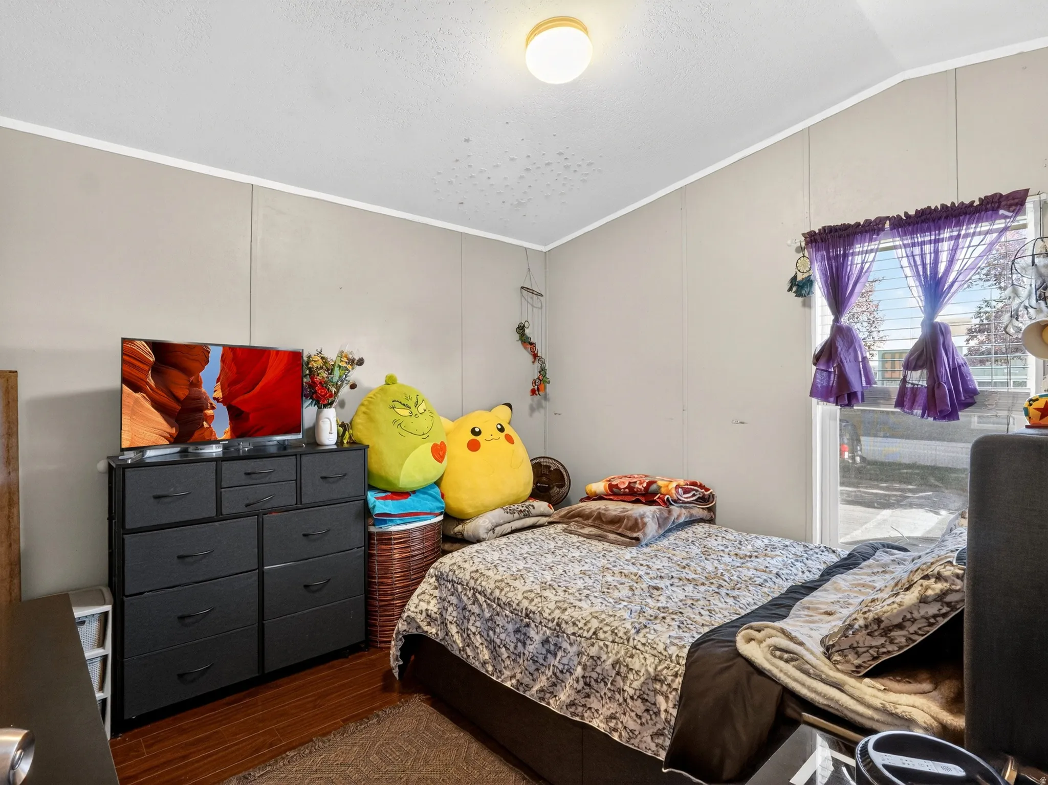 Bedroom featuring paneled walls, white crown molding, and a ceiling-mounted light fixture