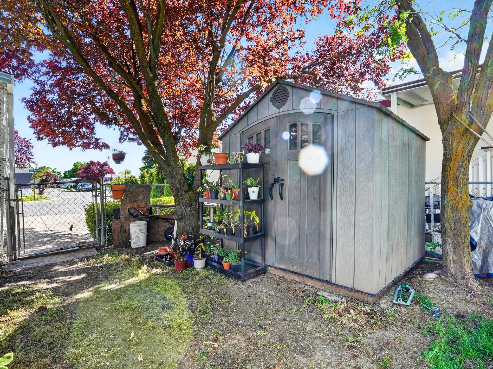 Freestanding storage shed with wood-look siding and arched double doors