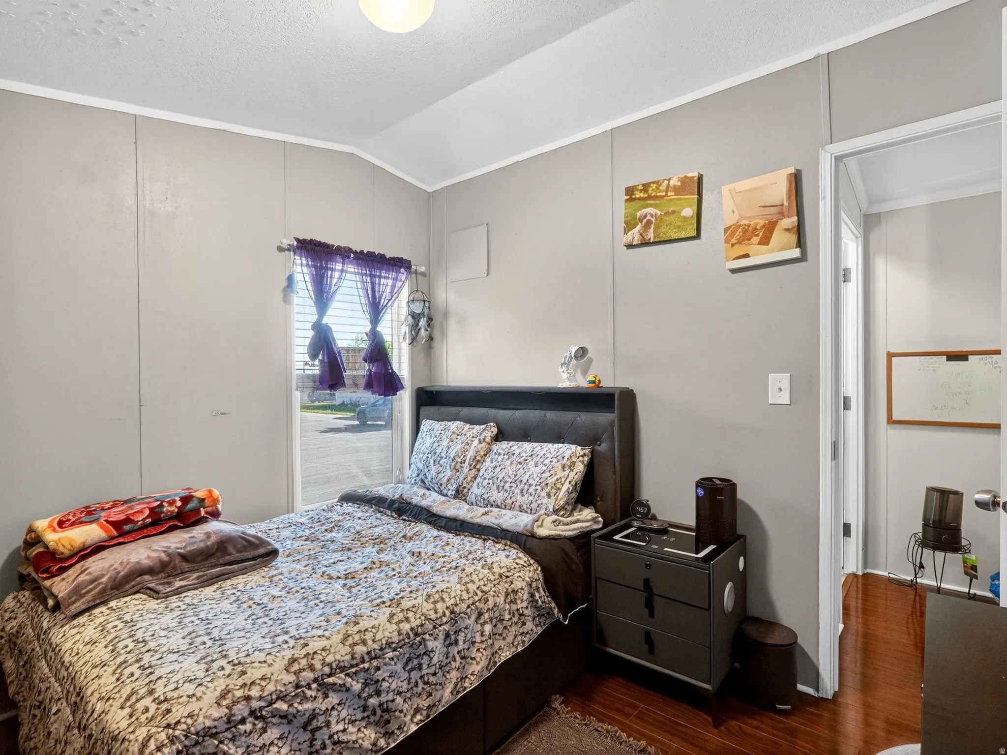 Bedroom featuring wood-finish flooring and light gray panel walls