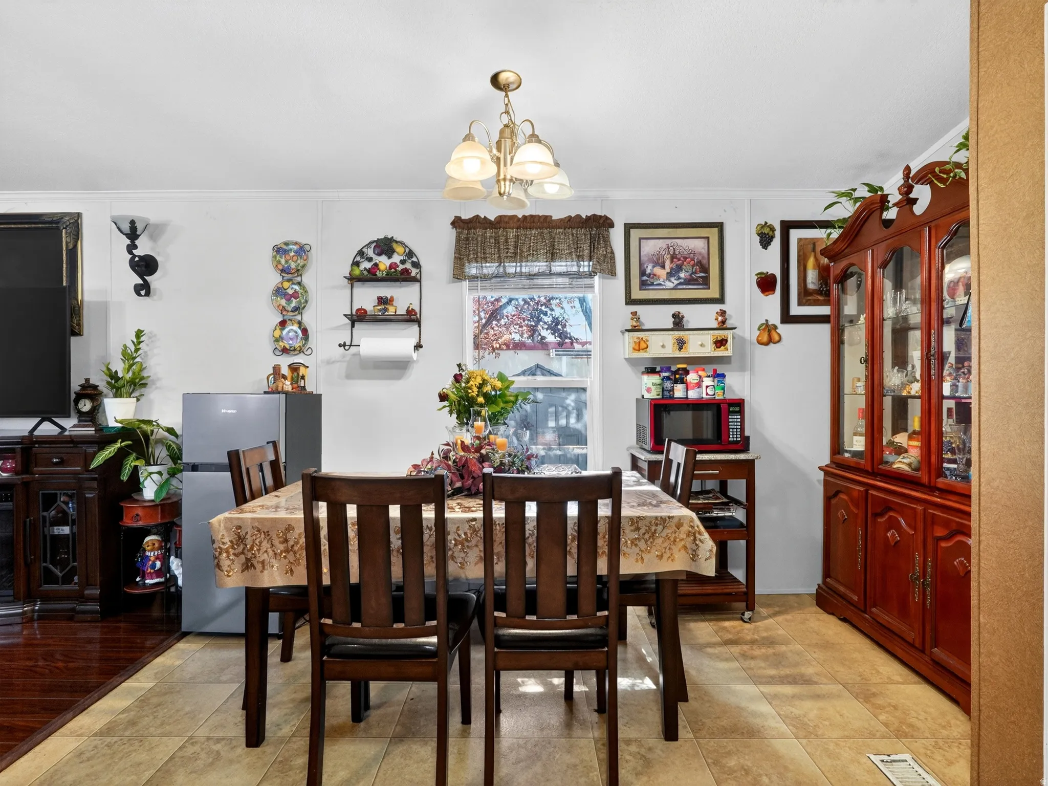 Dining space featuring tile flooring and a chandelier light fixture