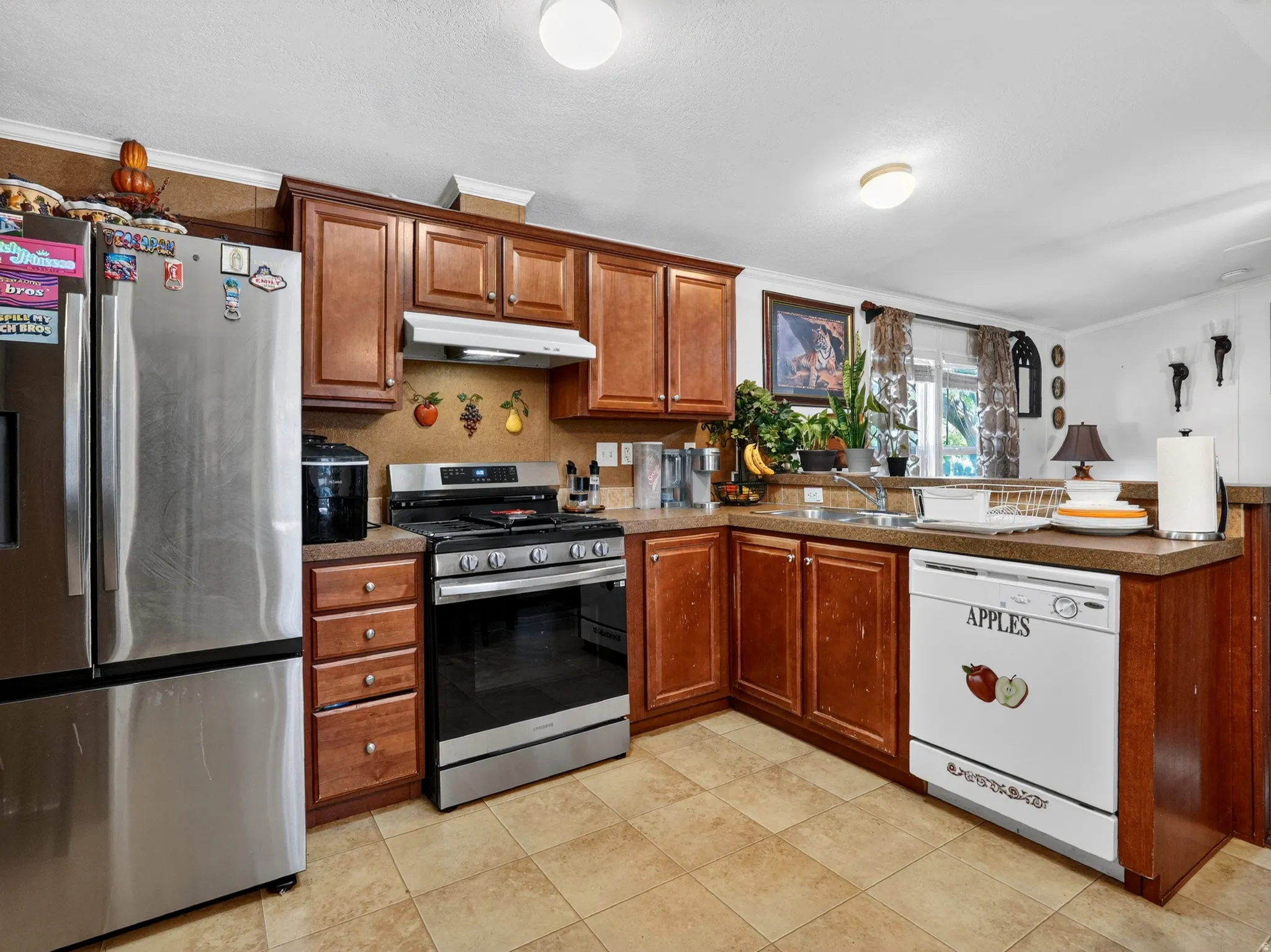 U-shaped kitchen featuring wood-finish cabinetry, a stainless steel range, and a dual-basin sink