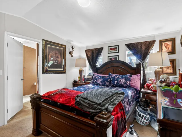 Bedroom featuring a paneled accent wall, carpet flooring, and a ceiling light fixture