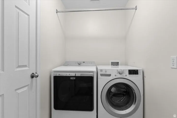 Dedicated laundry space featuring a hanging rod and white walls