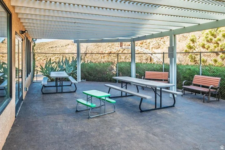 Covered outdoor patio area featuring a slatted pergola roof