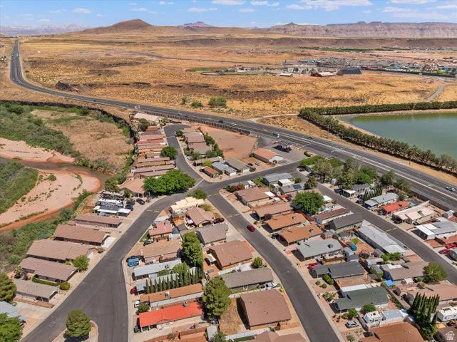 Residential neighborhood featuring diverse single-story homes with paved roads, desert landscaping, and a nearby riverbed