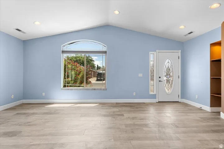 Vaulted ceiling living space with wood-finish flooring