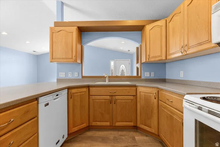 Kitchen featuring a built-in dishwasher, ample cabinetry, and an integrated sink with a faucet