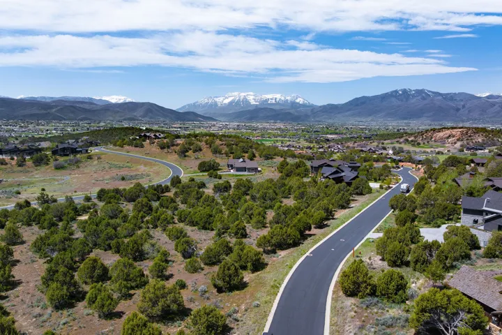 Expansive land parcel featuring natural shrubbery and established residential roads