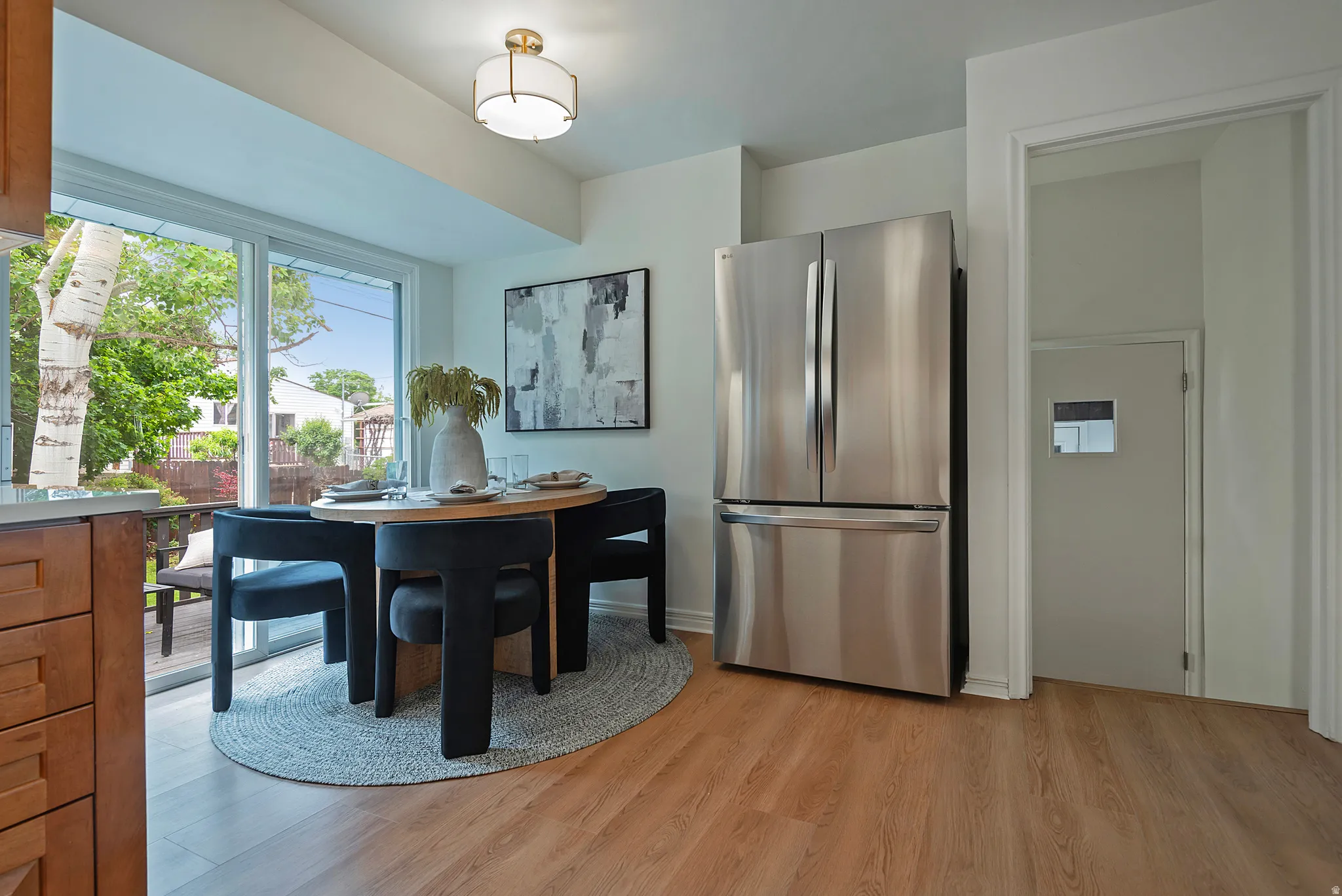 Kitchenette featuring wood-finish flooring, a stainless steel French door refrigerator, and a contemporary flush mount light fixture