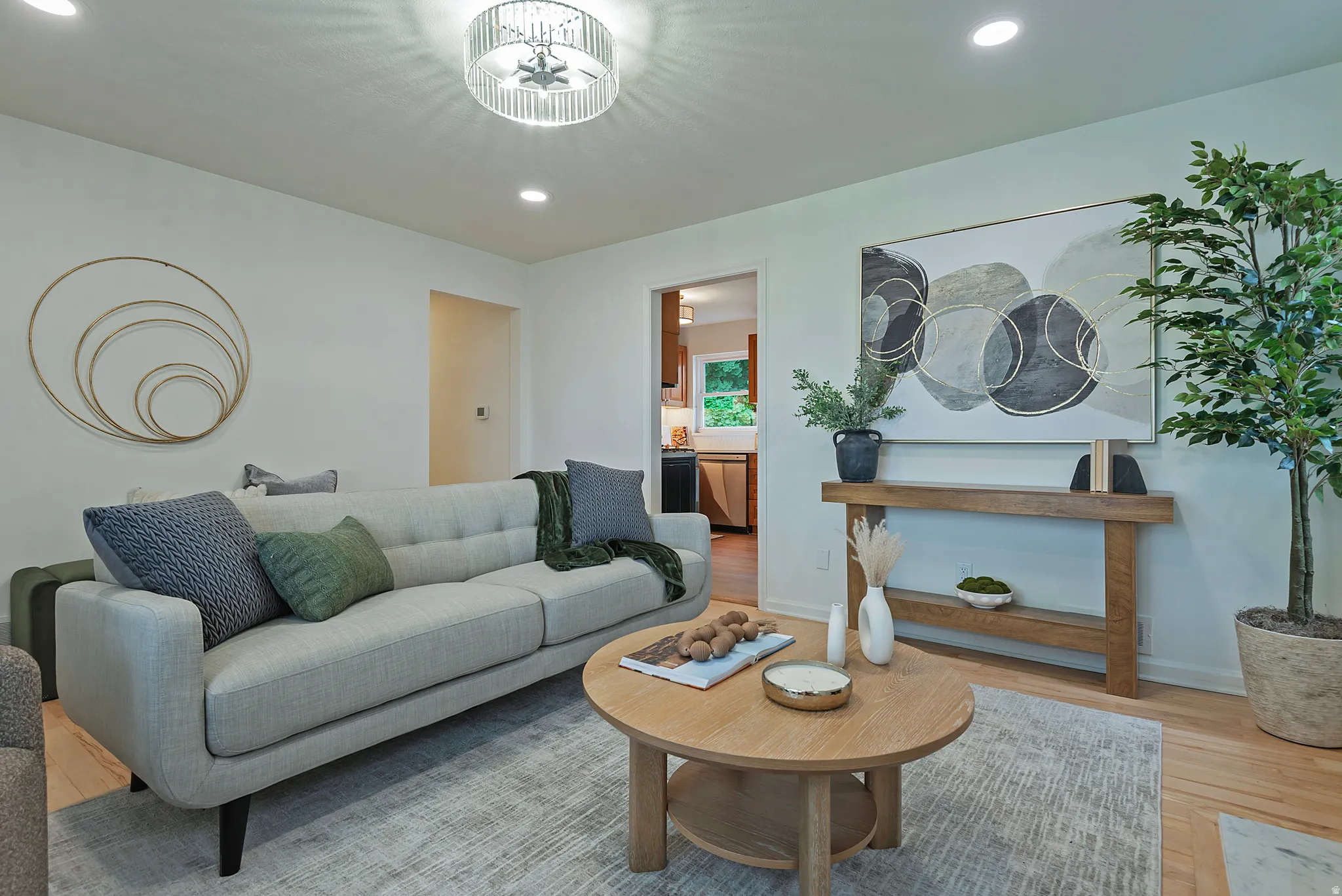 Living area featuring light wood-finish flooring, recessed lighting, and a contemporary ceiling fixture