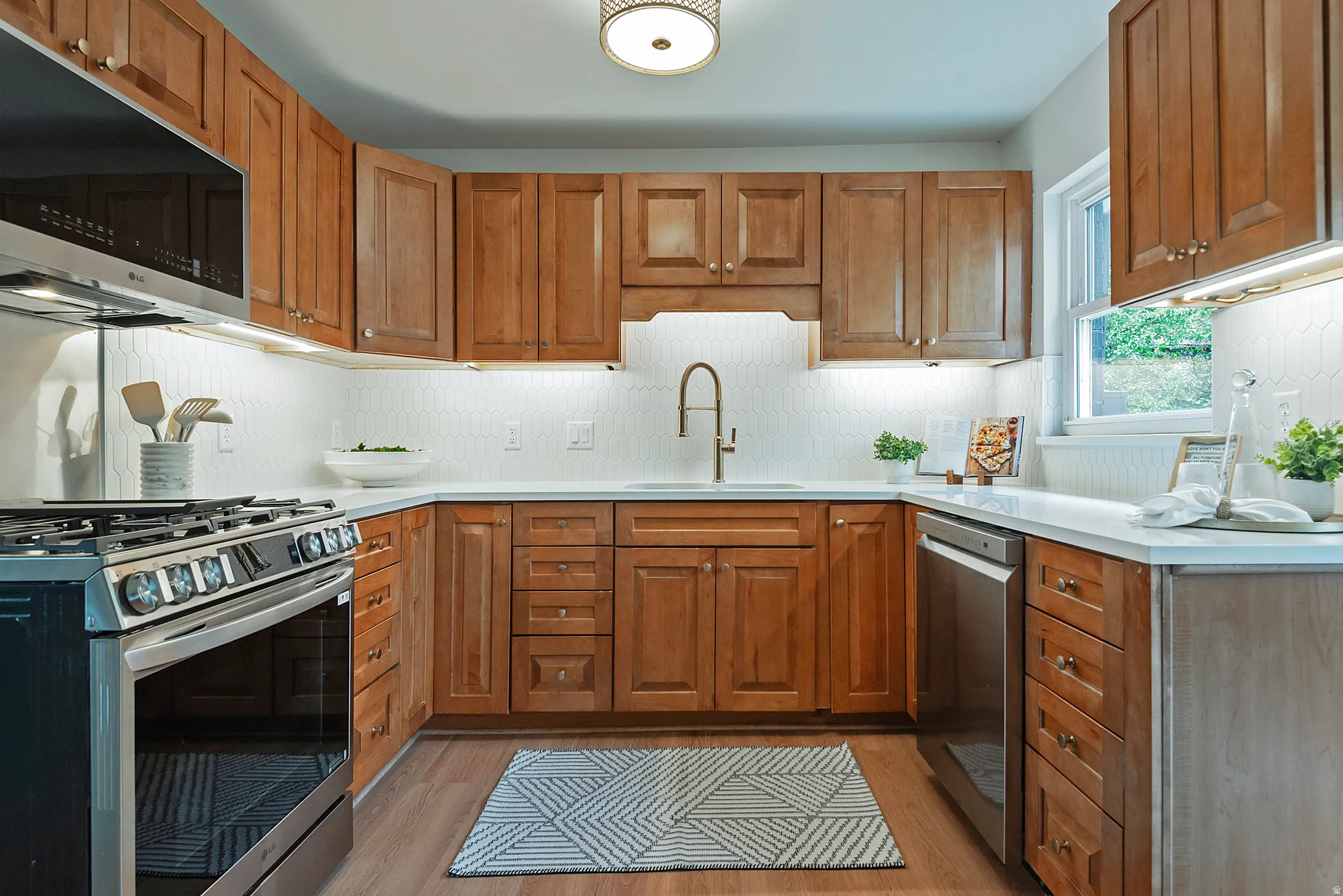 U-shaped kitchen featuring wood cabinetry, white countertops, and a white hexagonal tile backsplash