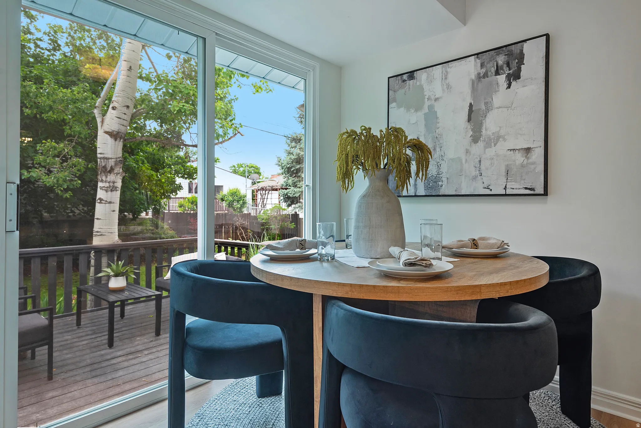 Dining area with wood-finish flooring and direct access to an outdoor deck through sliding glass doors