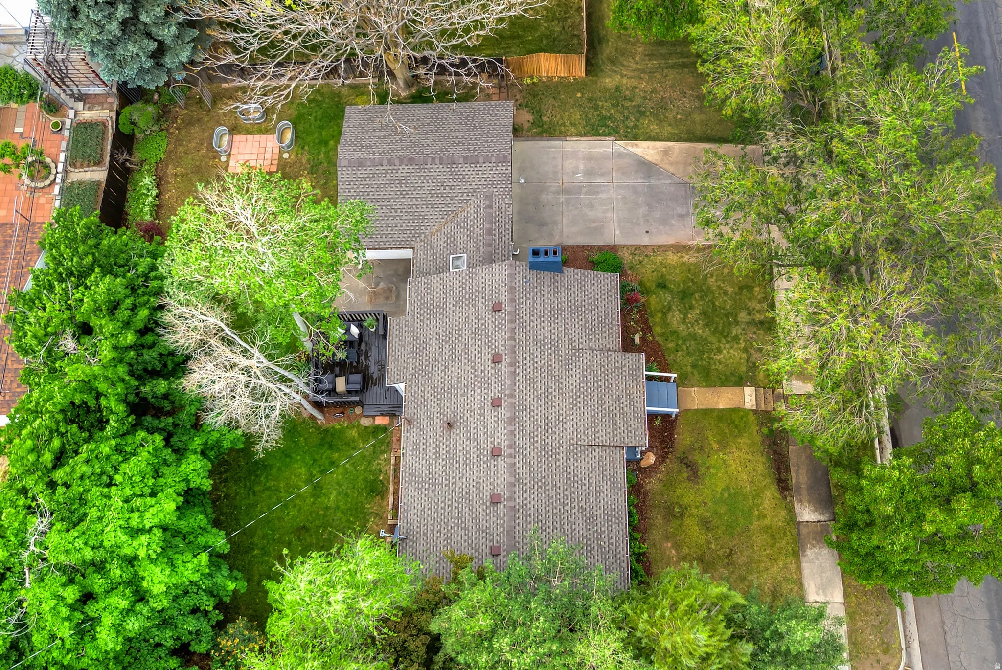Expansive property featuring a multi-gabled roofline, mature trees, and a spacious green lawn