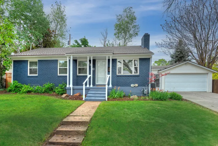 Blue brick exterior featuring a covered porch, white columns, and a front entry