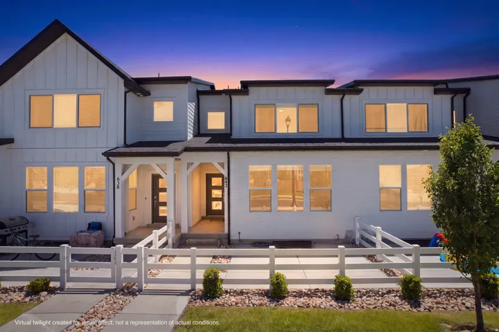 Modern farmhouse-style exterior with white siding, dark trim, and multiple windows