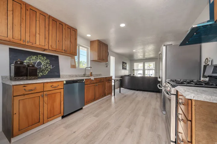 Kitchen featuring wood cabinetry, light-toned countertops, and stainless steel appliances