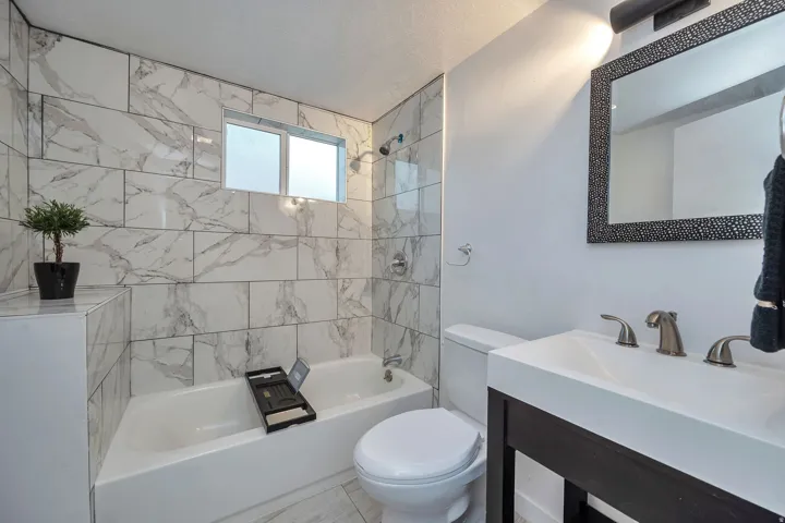 Bathroom featuring a contemporary vanity with an integrated sink, textured mirror, and brushed nickel fixtures