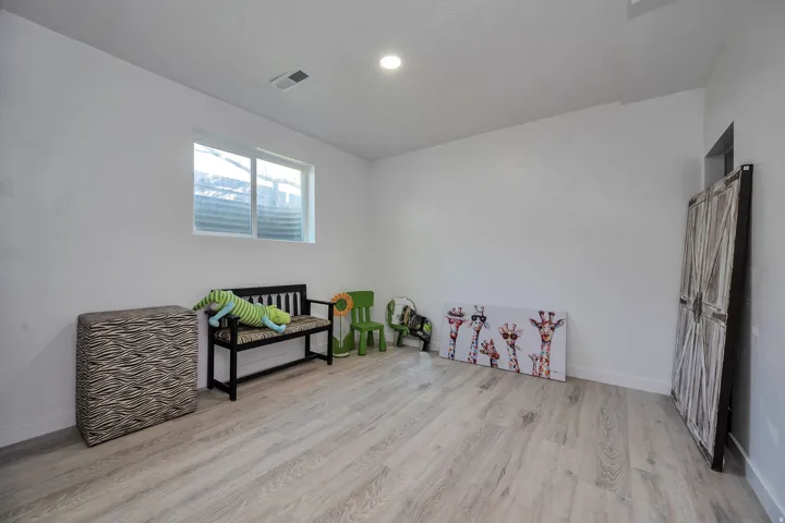 Room featuring light wood-finish flooring, white walls, and a recessed ceiling light