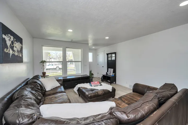Bright living area featuring recessed lighting, light wood-finish flooring, white walls, and multiple windows