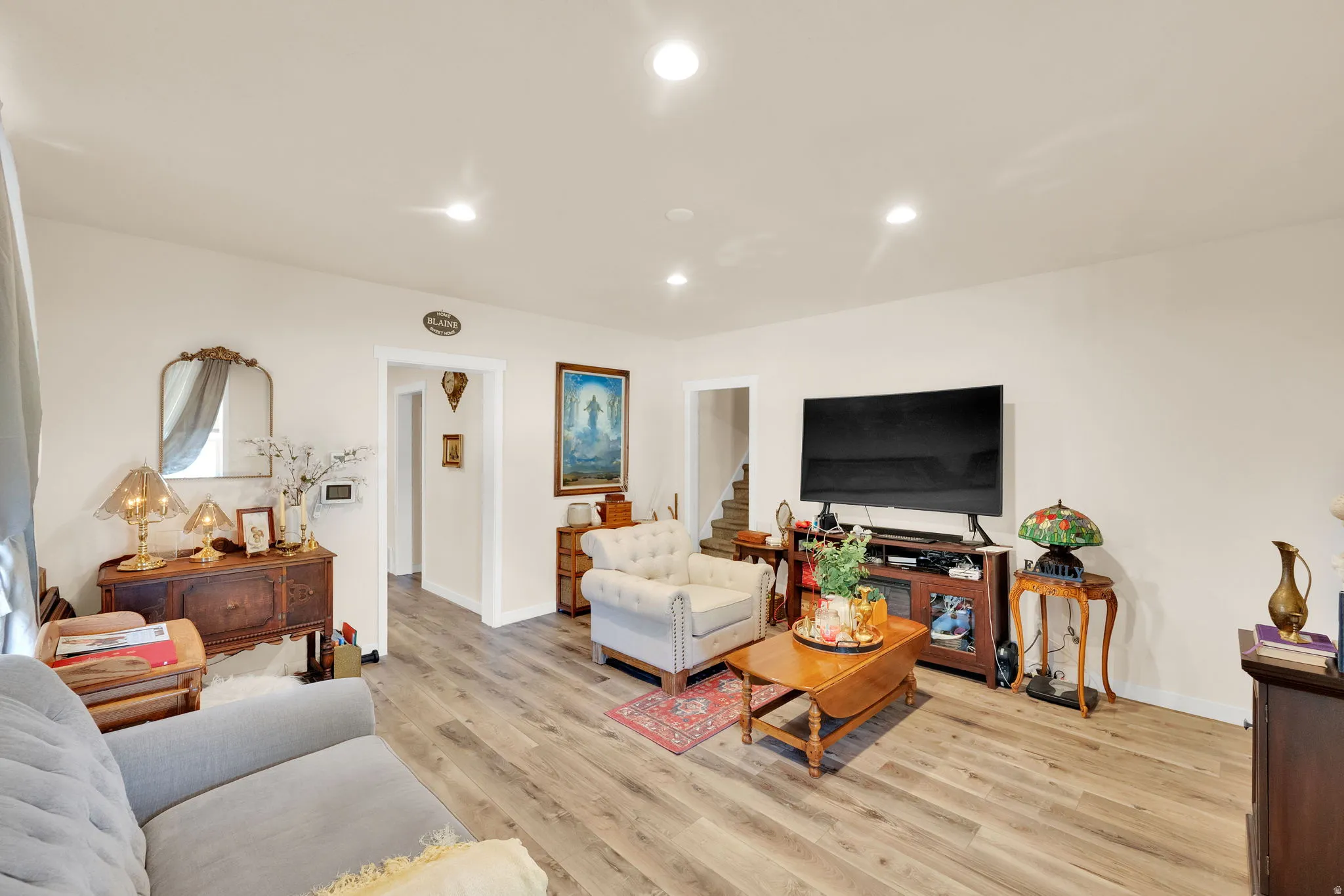 Open-concept living space featuring wood-finish flooring, recessed lighting, and crisp white walls