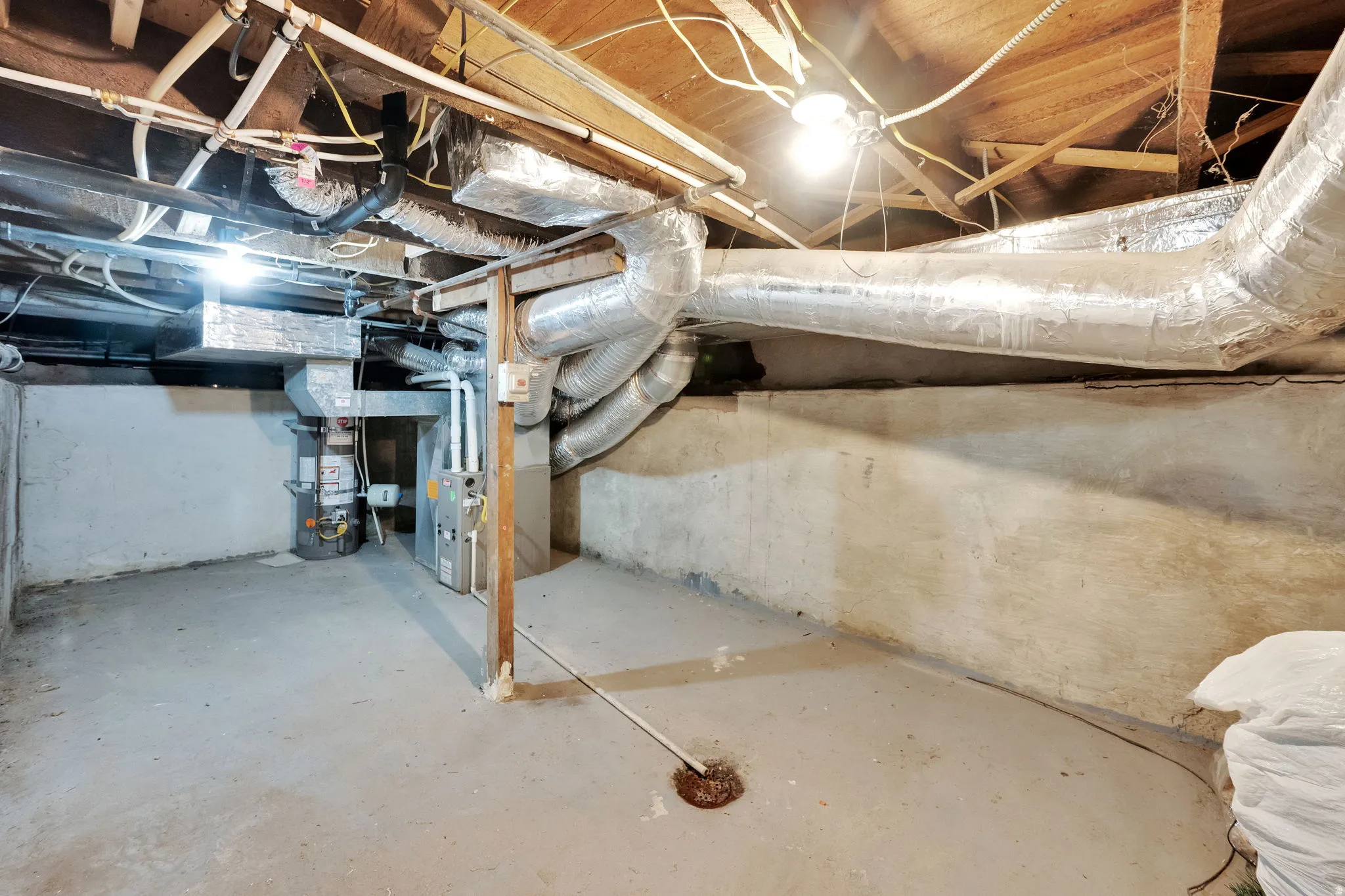 Unfinished basement with concrete flooring and exposed ceiling joists