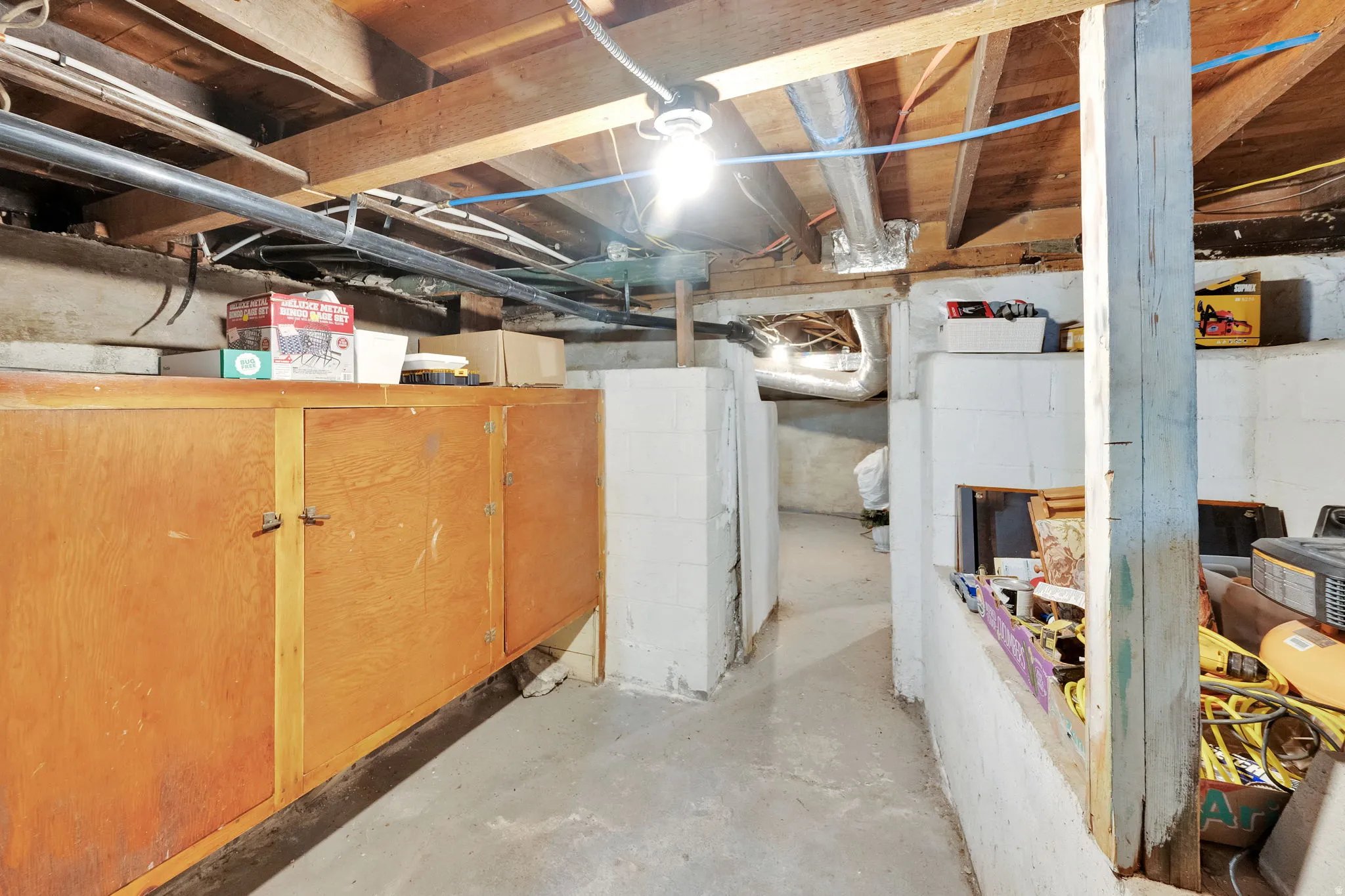 Basement area featuring exposed wood joists and concrete flooring