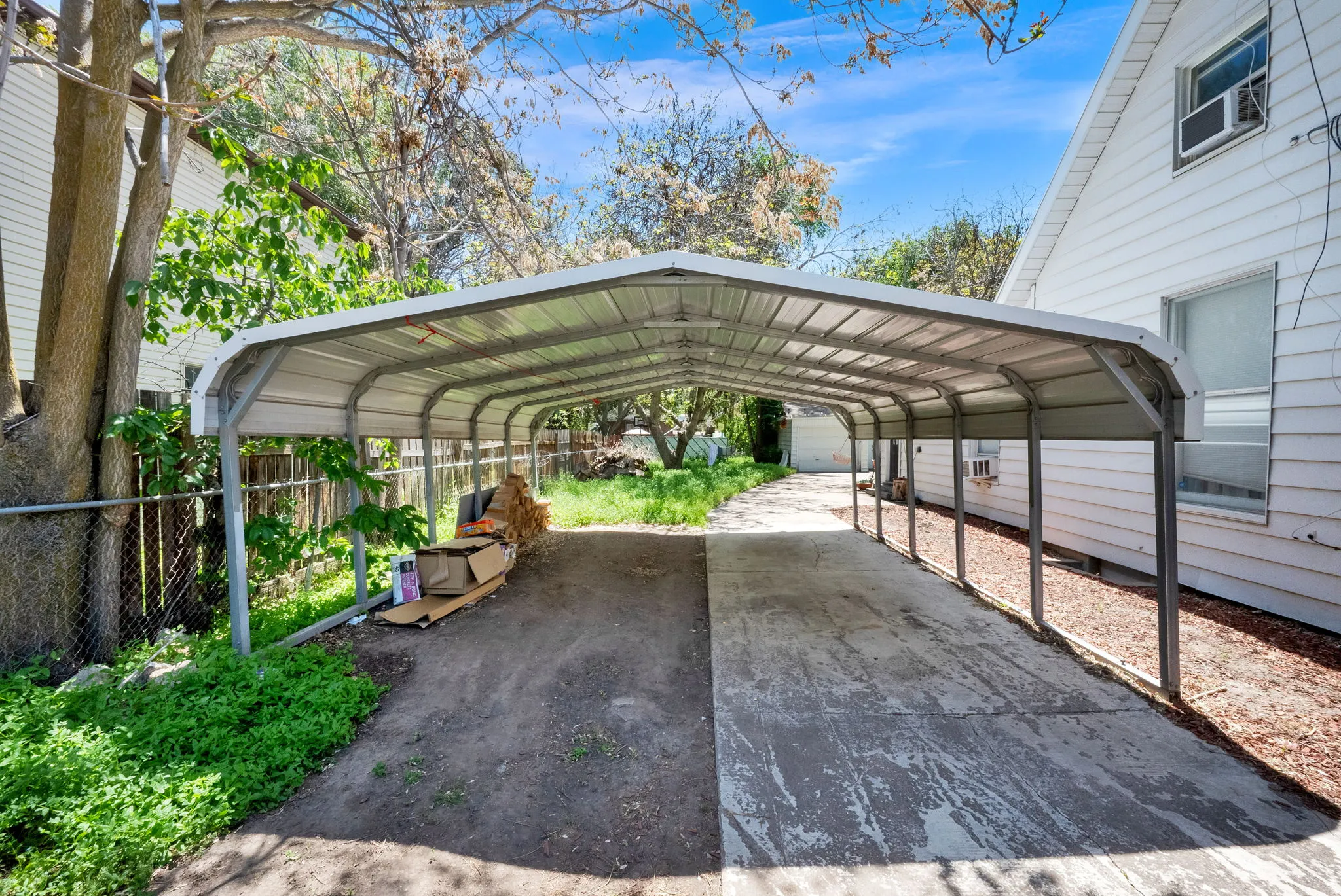 Extended metal carport structure providing covered parking