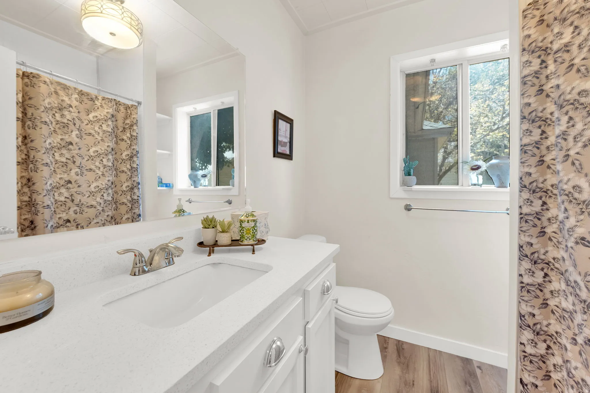 Bathroom featuring a white vanity with an integrated sink, chrome faucet, and spacious mirror