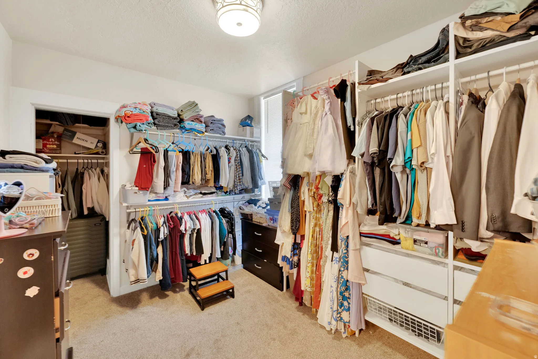Custom closet organization system featuring multiple hanging rods and integrated shelving