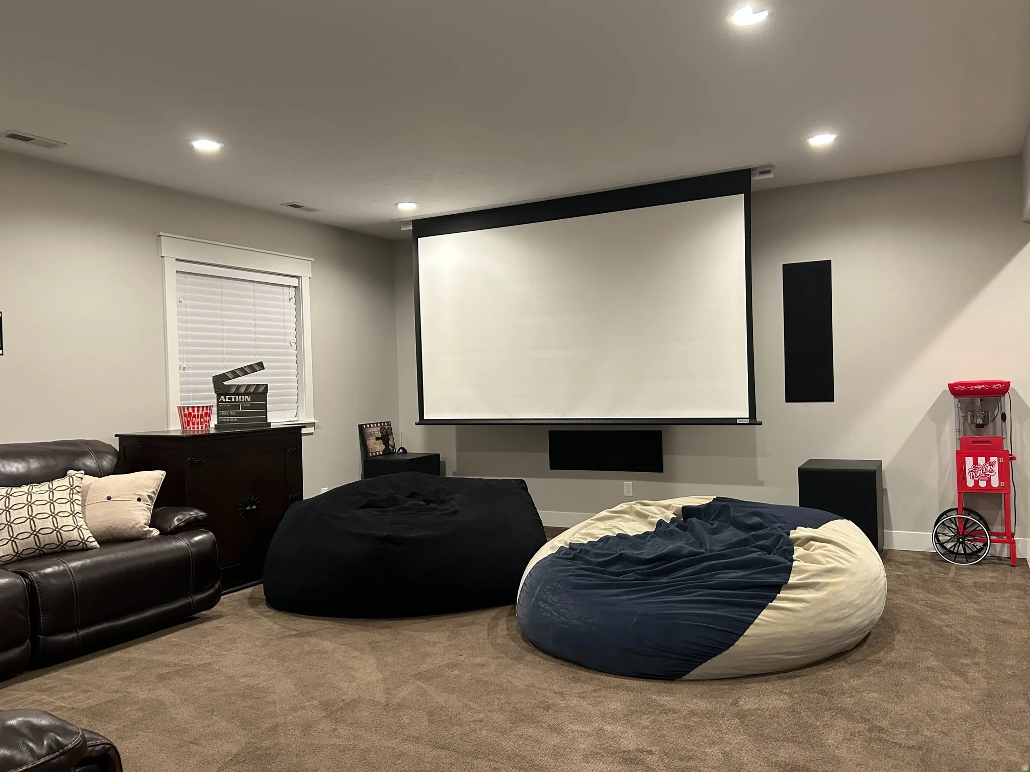 Dedicated media room featuring a large projector screen and recessed lighting
