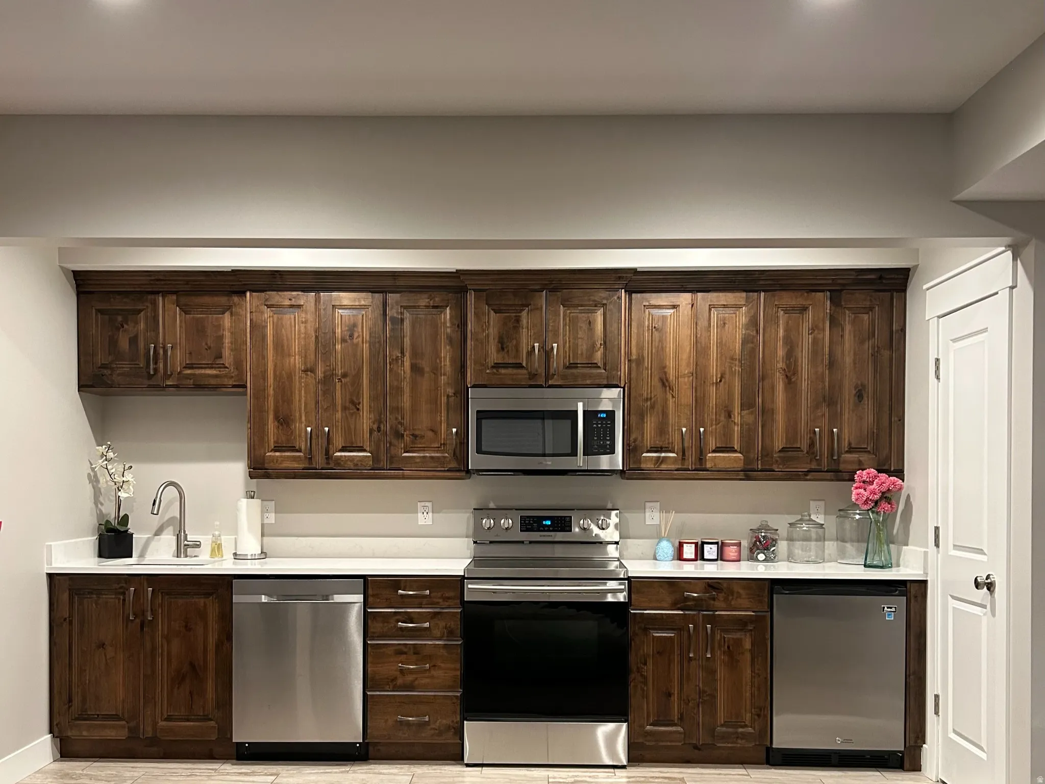 Full kitchen featuring rich wood cabinetry, stainless steel appliances, white countertops, and recessed lighting