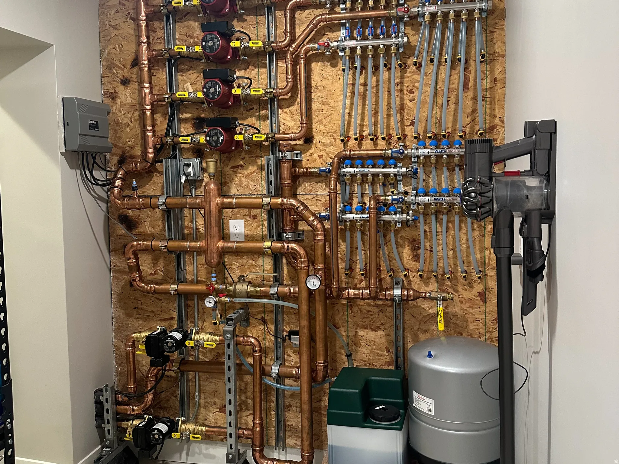 Hydronic heating system featuring extensive copper piping, multiple pumps, and distribution manifolds