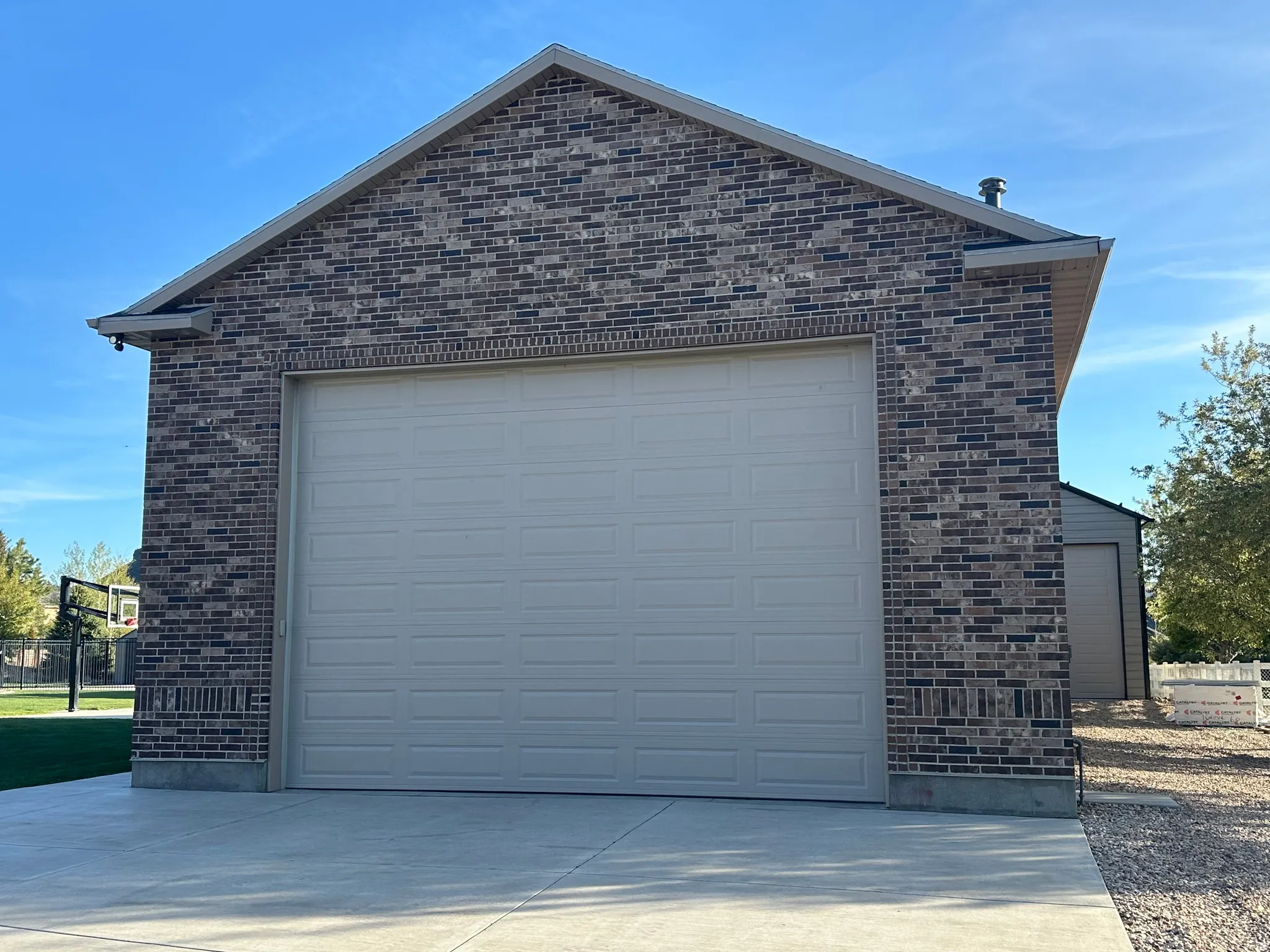 Brick exterior featuring a paneled garage door and concrete driveway