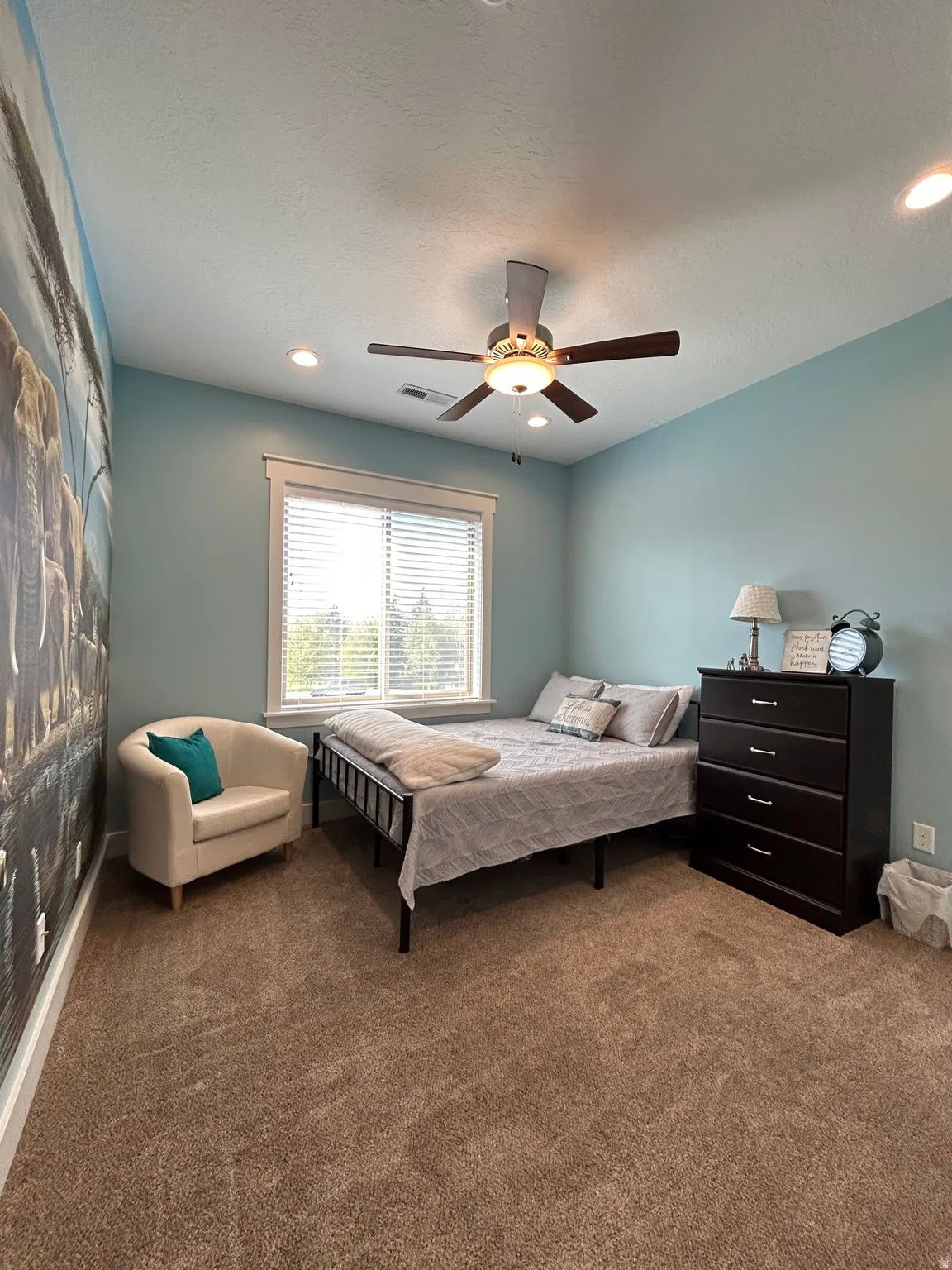 Expansive room featuring plush carpeting, a large window with white blinds, a ceiling fan with integrated lighting, and recessed ceiling lights