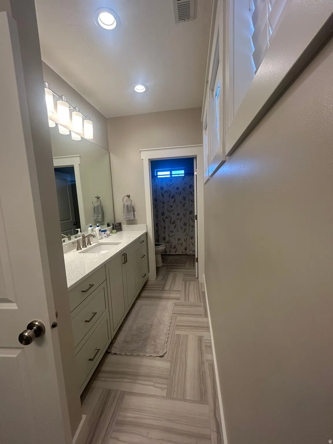 Bathroom featuring a spacious dual vanity with light-toned cabinetry and a light-colored countertop