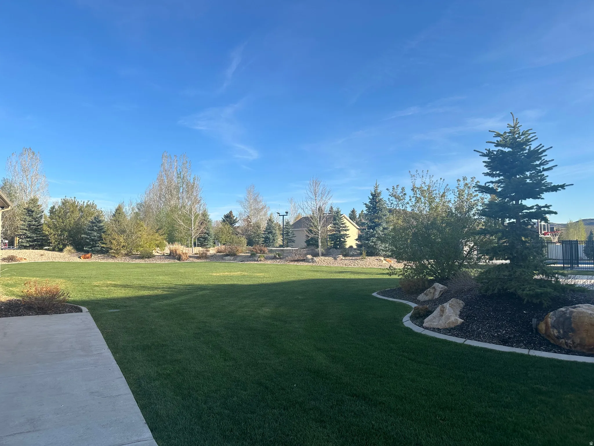 Expansive green lawn with a defined concrete patio area