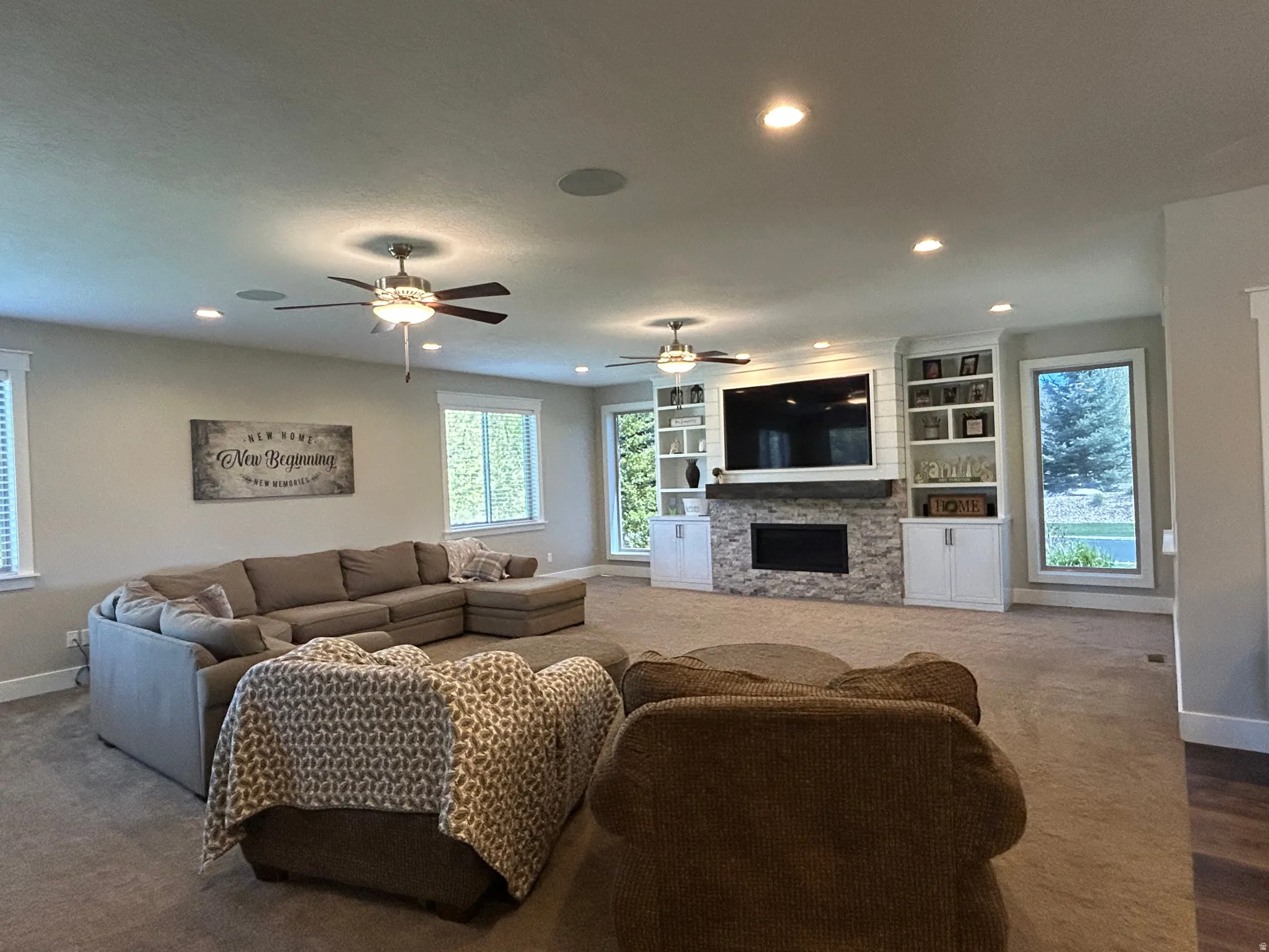Spacious room featuring recessed lighting, ceiling fans, and built-in cabinetry with shelving