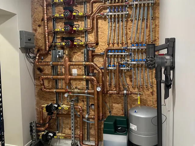 Hydronic heating system featuring extensive copper piping, multiple pumps, and distribution manifolds