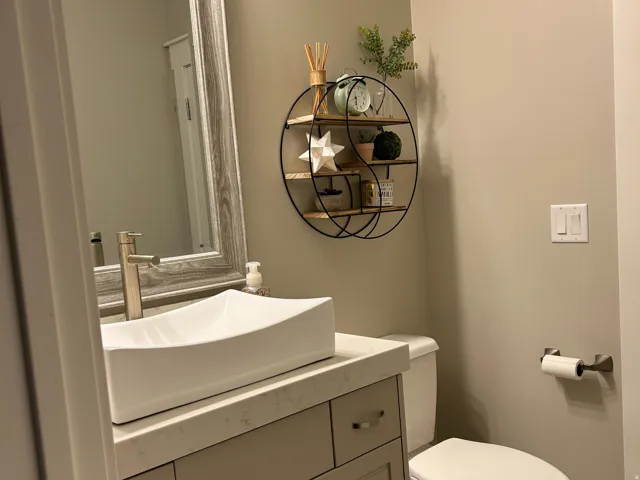Modern vanity with a rectangular vessel sink, solid surface countertop, and brushed nickel faucet