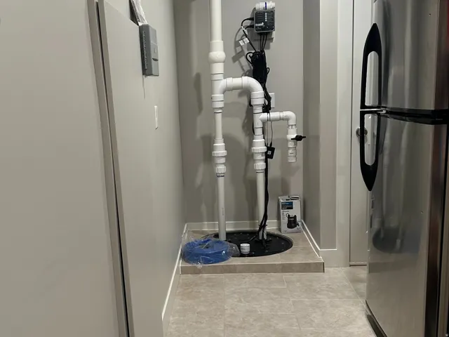 Utility area featuring a sump pump system with PVC piping, recessed lighting, and durable tile flooring